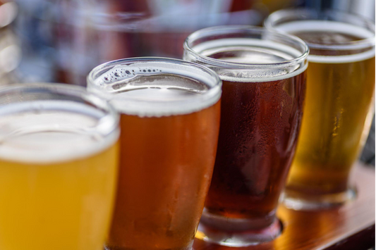 Four beer glasses side by side on a bar