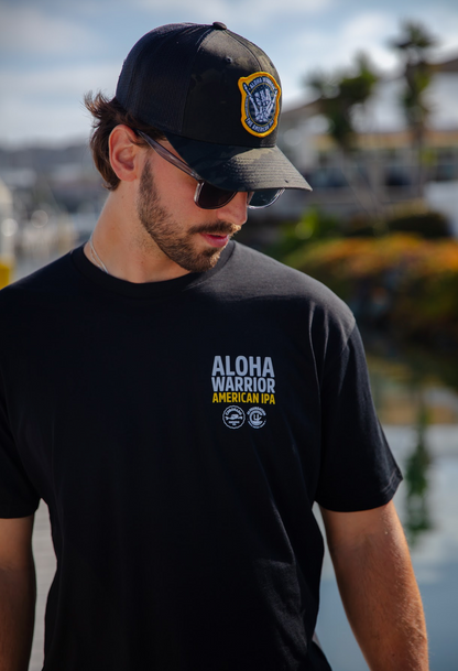 Man wearing a black cap and black t-shirt with 'Aloha Warrior American IPA' text.