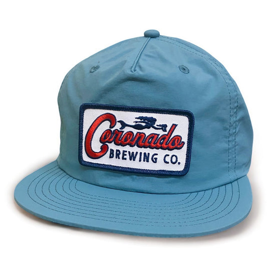 Blue cap with Coronado Brewing Co. patch on a white background